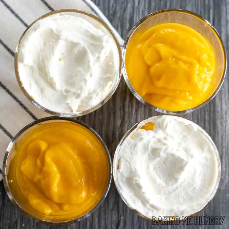 overhead shot of four cups of mango pudding, two with whipped cream, two without