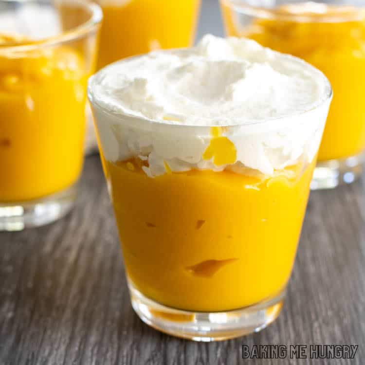 small cup of mango pudding without gelatin topped with whipped cream