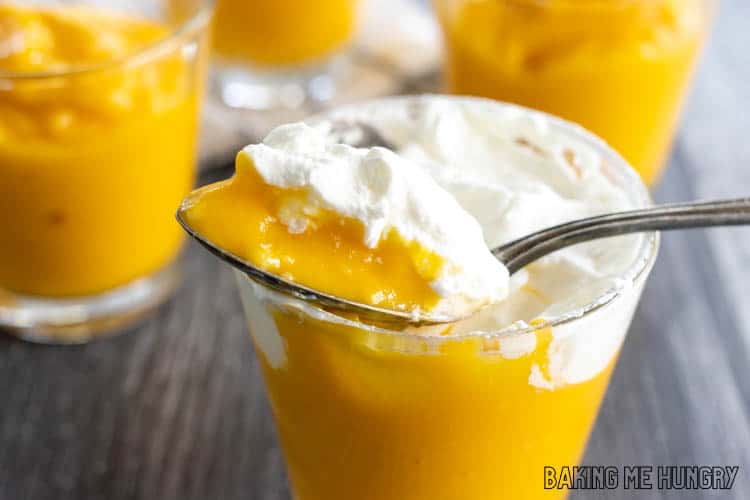 mango curd and whipped cream on spoon