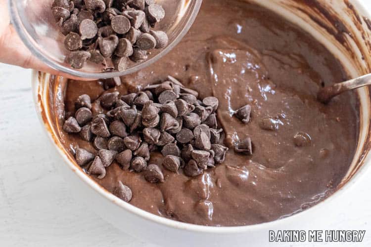chocolate chips being added to bowl of batter