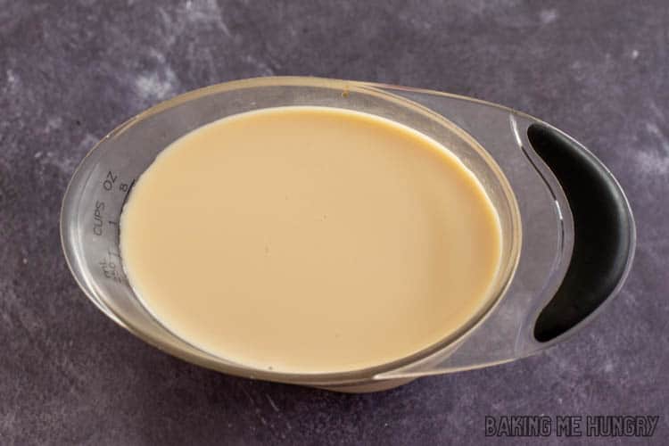 milk and tea mixture in measuring cup