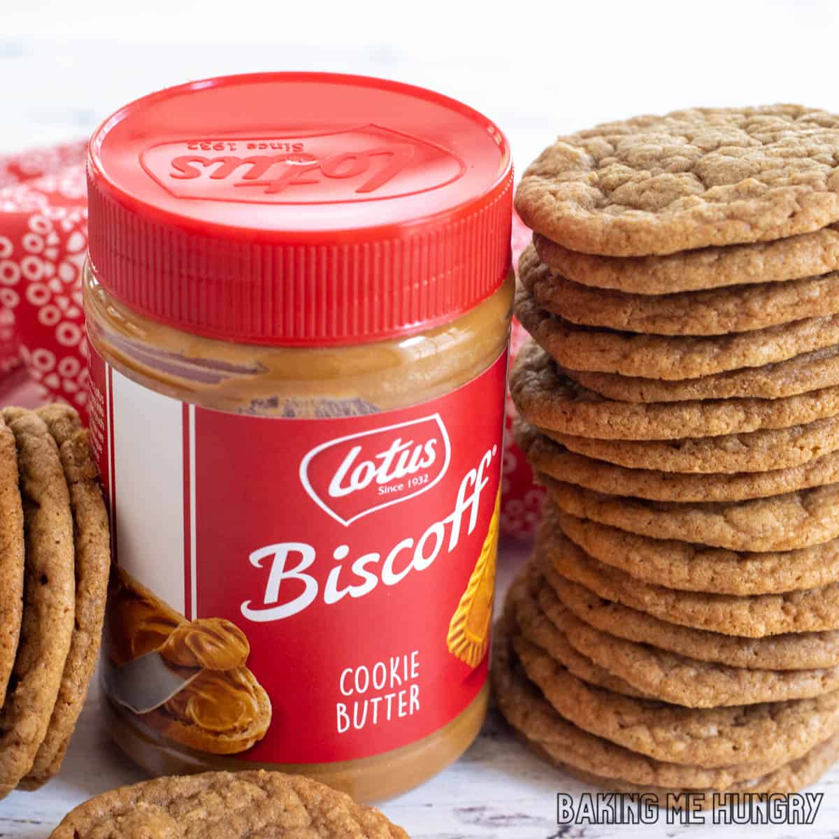 close up of biscoff butter cookies stacked up next to a can of cookie butter