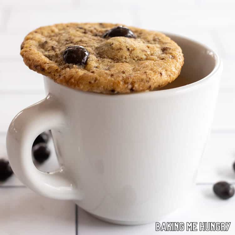 one of the coffee cookies sitting on top of a small mug of coffee
