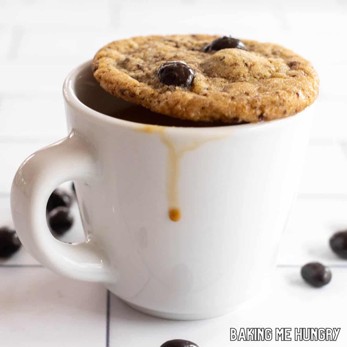 one of the coffee cookies sitting on top of a small mug of coffee with a drip of coffee going down the side