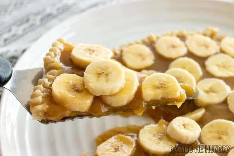 slice of banana tart with caramel being lifted up with spatula