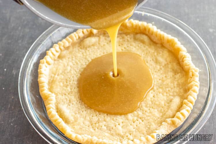 golden liquid being poured from pan into crust