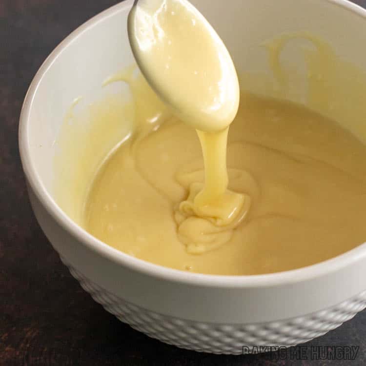 spoon lifting up melted white chocolate mixture