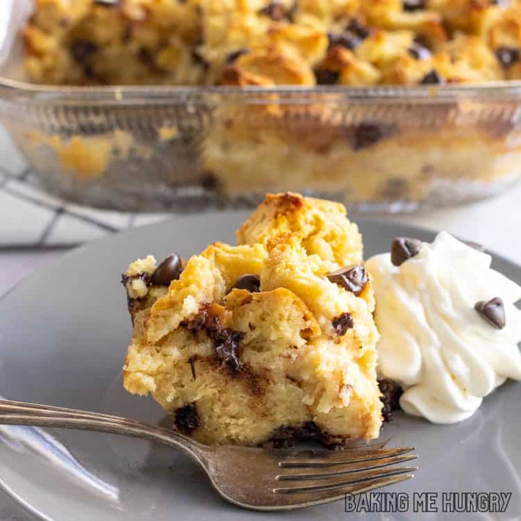 bread pudding with chocolate chips and whipped cream on a gray plate