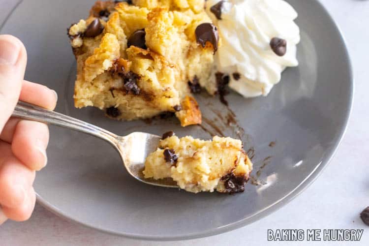 fork holding up a bite of chocolate chip bread pudding