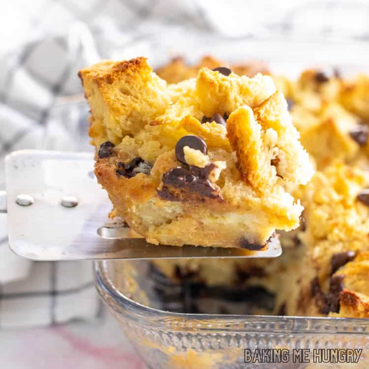 serving spatula lifting up a piece of the chocolate chip bread pudding