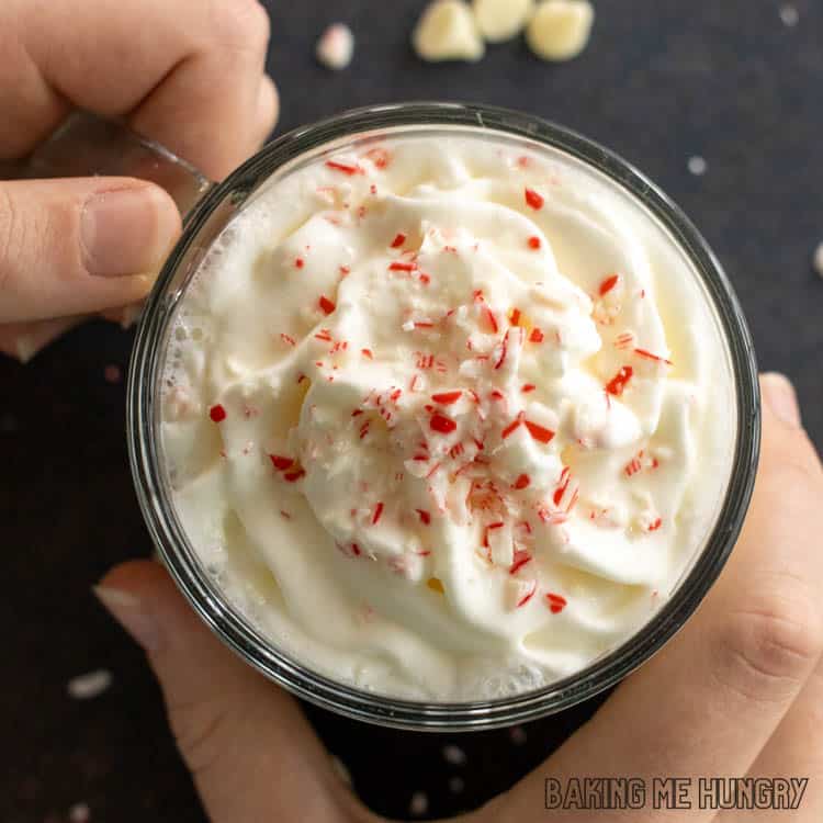 hands holding mug of starbucks white hot chocolate from overhead