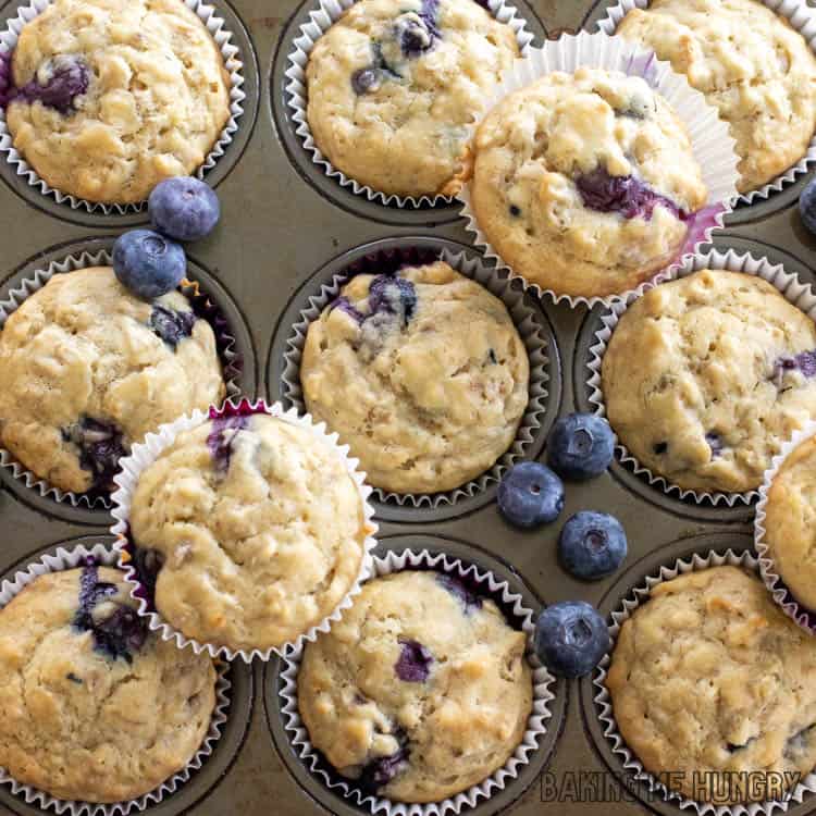 Banana Blueberry Oatmeal Muffins in baking pan with extra blueberries