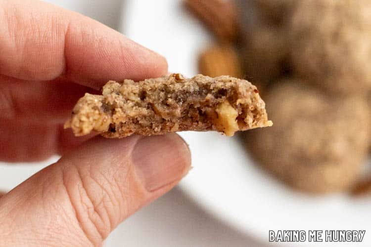 hand holding one of the brown butter pecan cookies with a bite missing