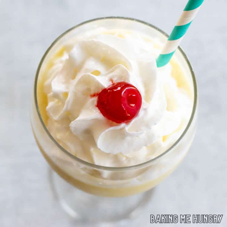 close up of whipped cream and cherry on pina colada mocktail