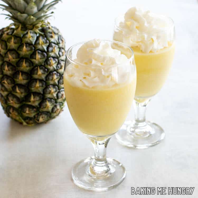 whipped cream on top of virgin pina colada in glasses