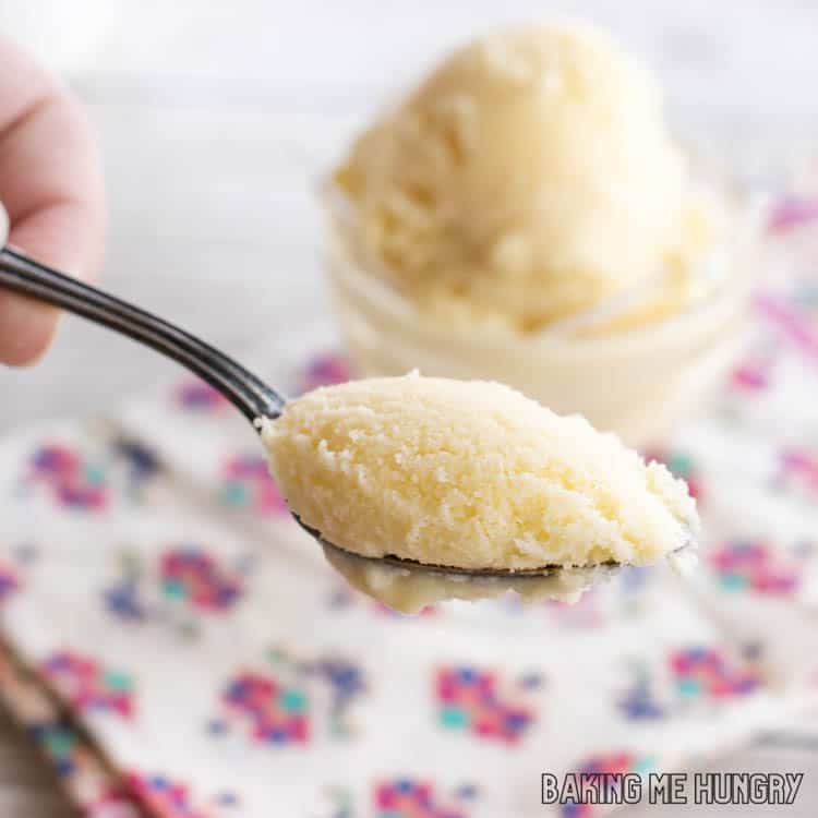 hand holding a spoon with a bite of passion fruit coconut milk ice cream on it