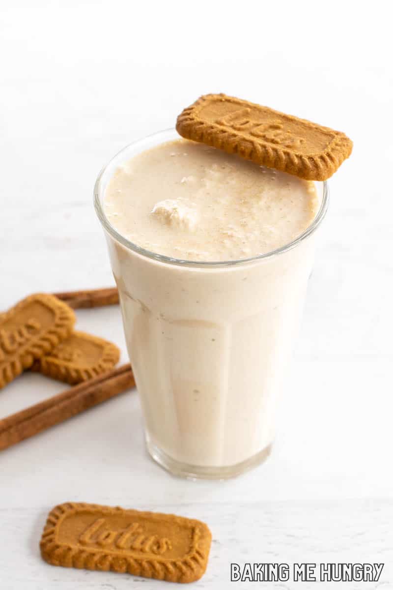 tall glass with biscoff milkshake topped with biscuit