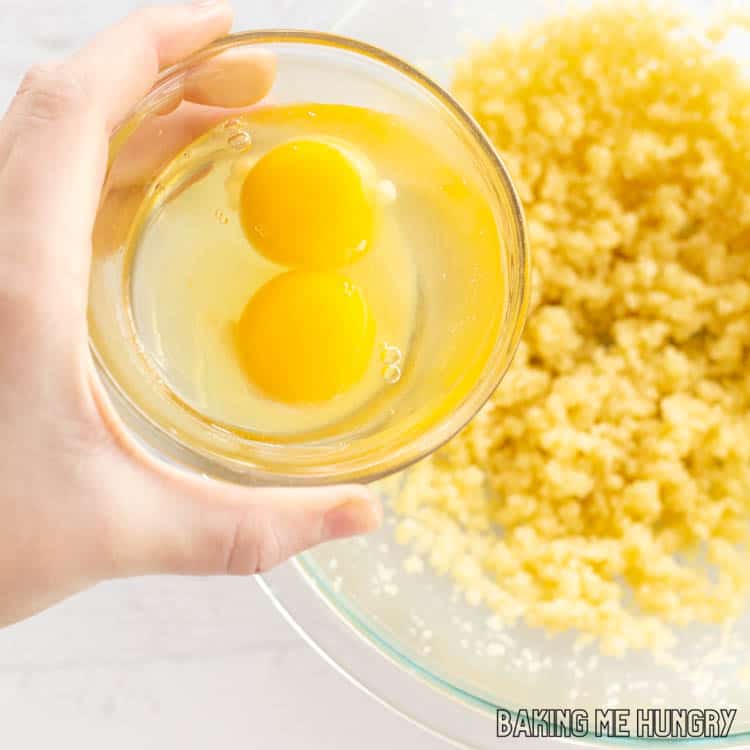 hand adding eggs to bowl