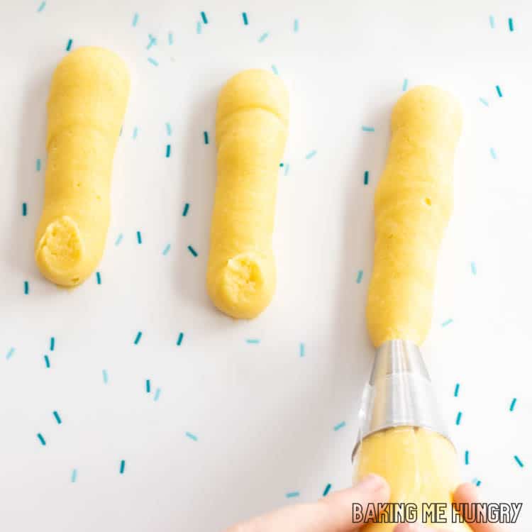 hands piping choux pastry dough