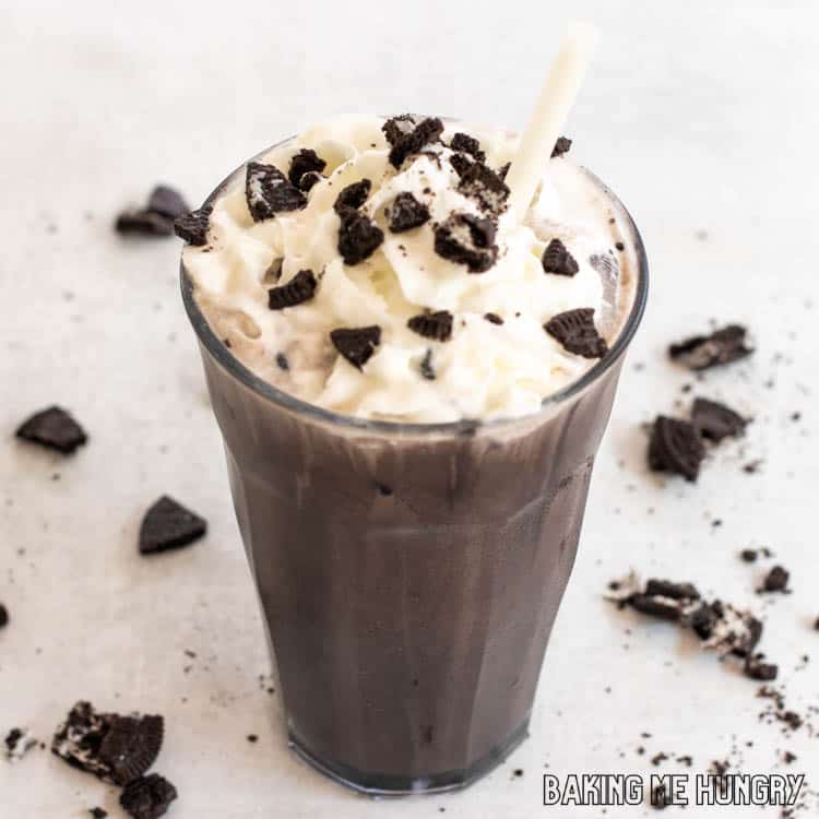 oreo iced coffee recipe in tall glass with whipped cream and crushed cookies