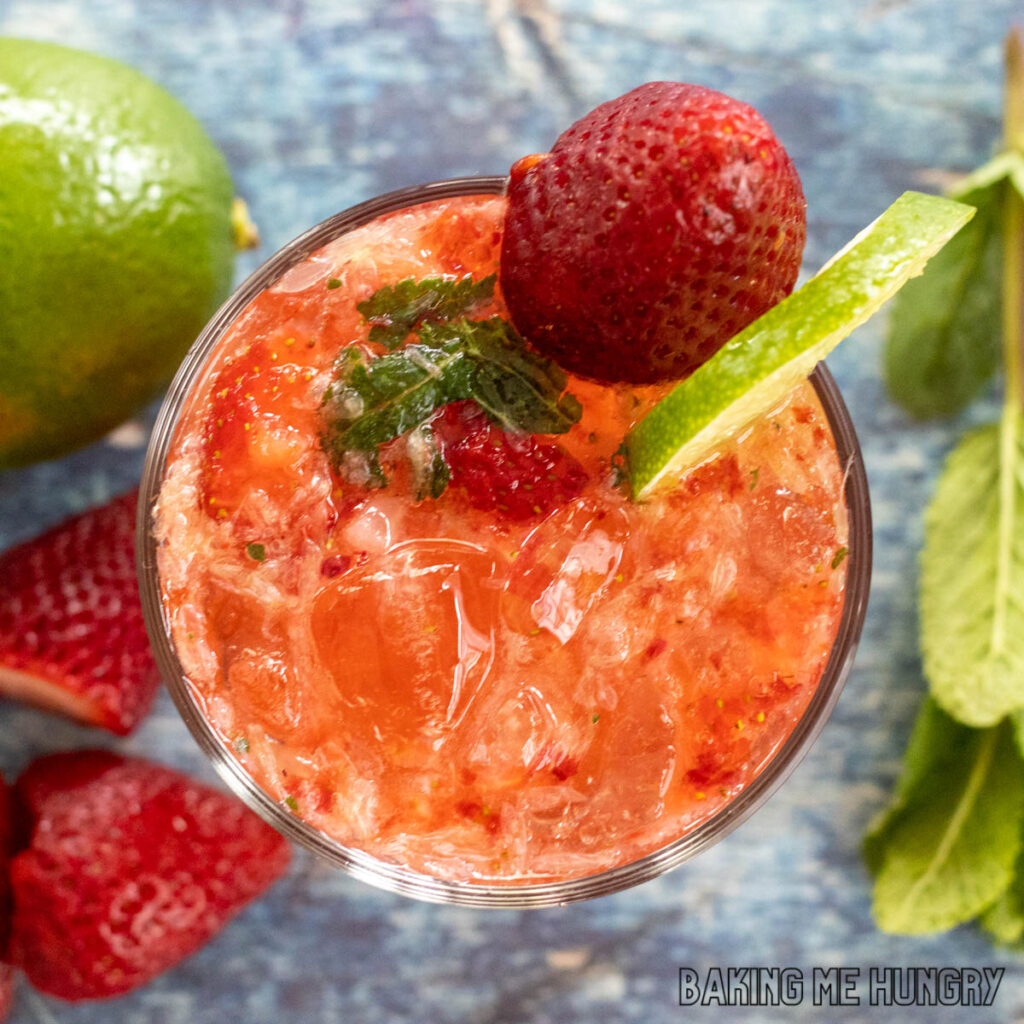 glass of virgin strawberry mojito garnished with a strawberry and lime slice from overhead