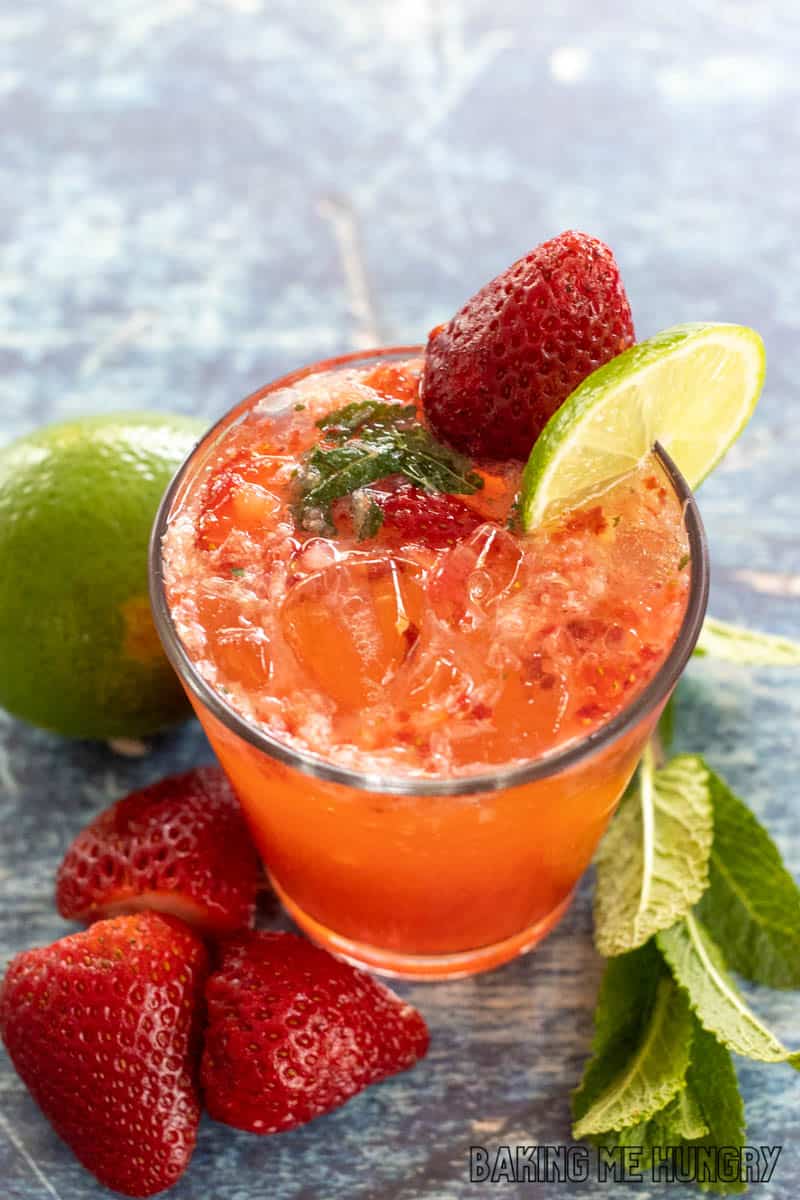 virgin strawberry mojito in a rocks glass garnished with a strawberry and lime slice