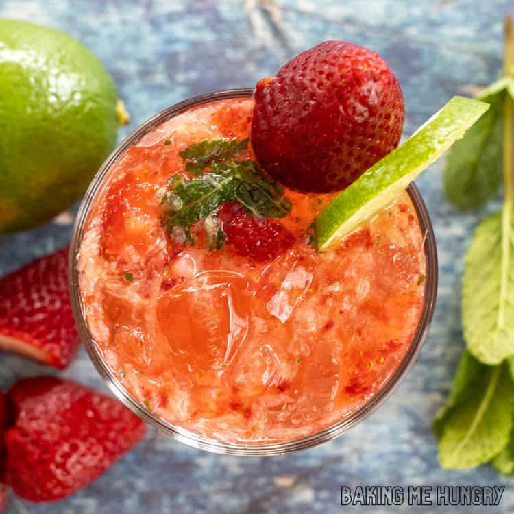 overhead shot of a glass of virgin strawberry mojito garnished with a strawberry and lime slice