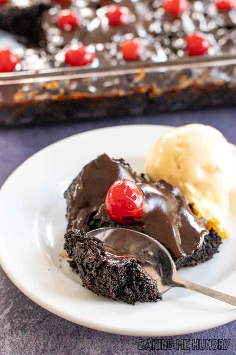 bite of one of the chocolate cherry brownies on a plate with vanilla ice cream