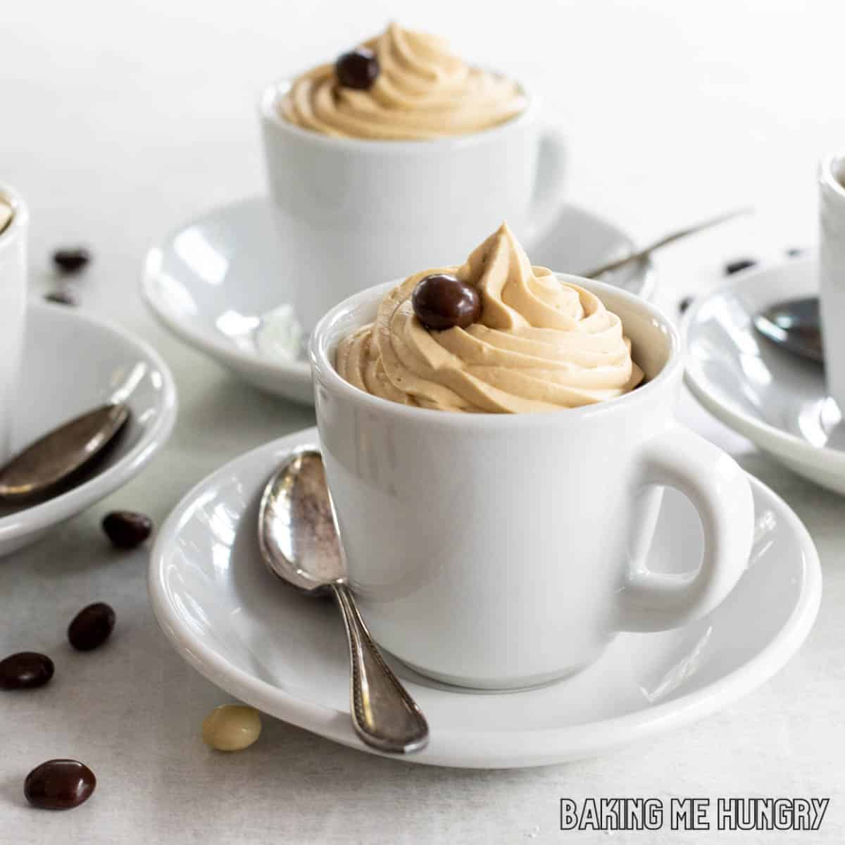 White cup of coffee and cinnamon tubes, spoon with ground coffee