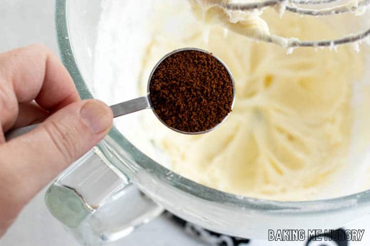 hand holding spoon of instant coffee powder