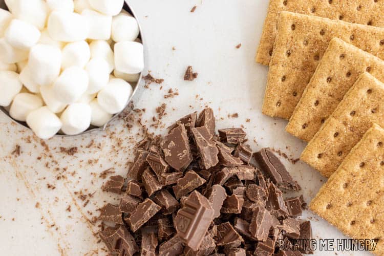 chopped chocolate next to mini marshmallows and graham crackers