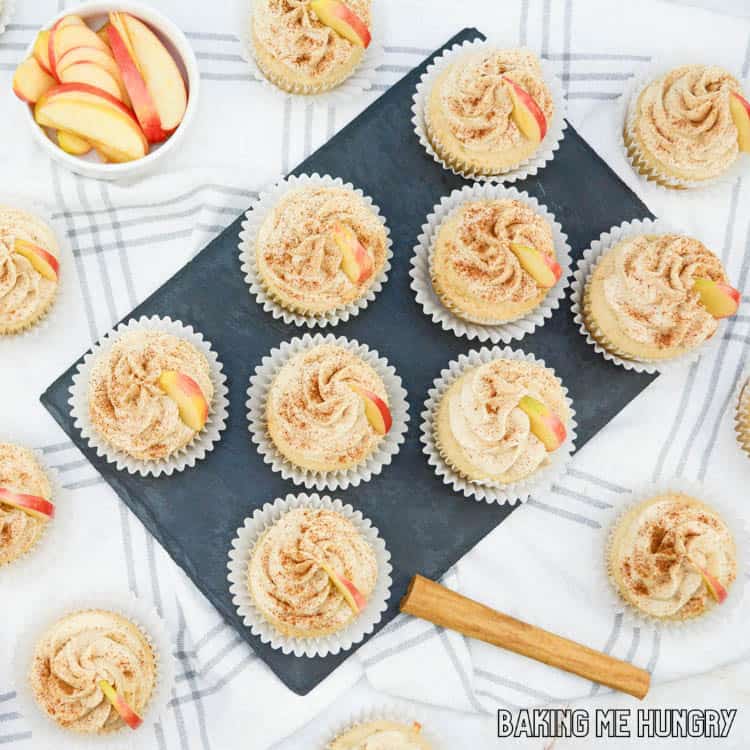 apple cider cupcakes garnished with cinnamon and apple slices on wire rack from overhead