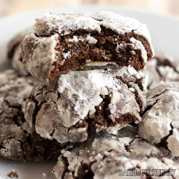 brownie crinkle cookies on a plate with one with a bite missing