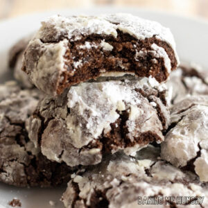 brownie crinkle cookies on a plate with one with a bite missing
