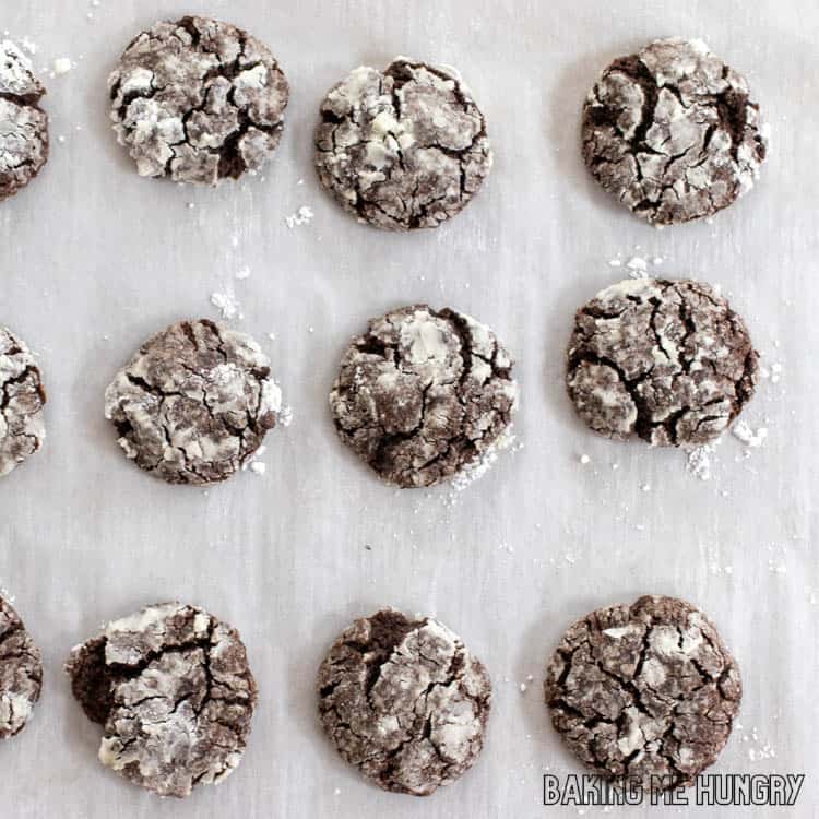 tray of baked brownie crinkle cookies on parchment paper