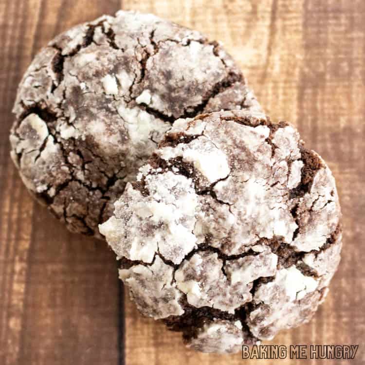 two brownie crinkle cookies on wood surface