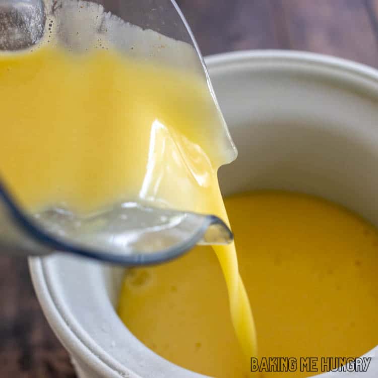 orange liquid being poured into freezer bowl