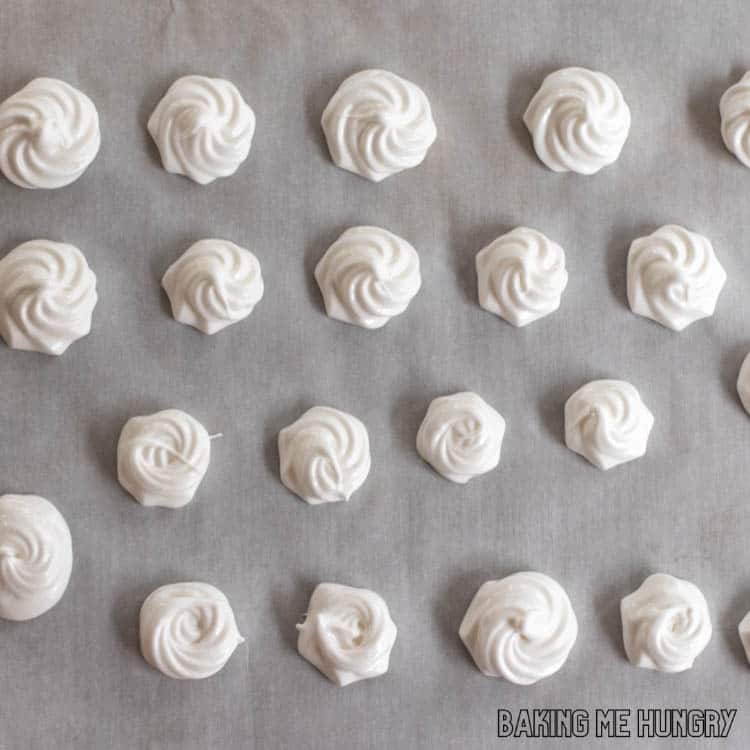 piped meringue cookies on parchment