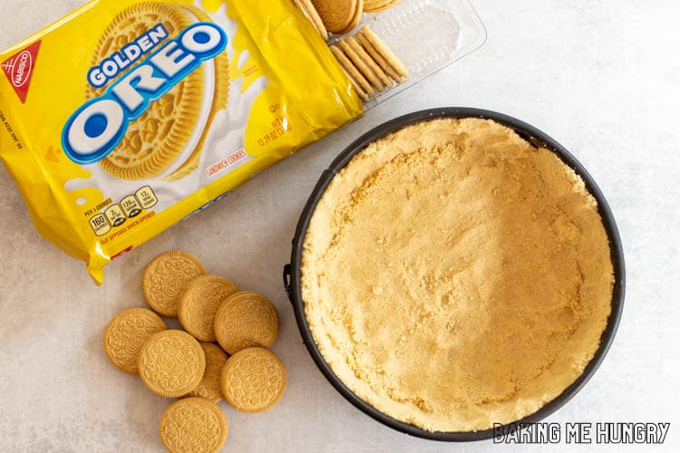 golden oreo crust in springform pan next to cookies
