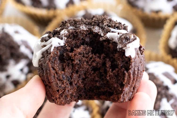 hand holding an oreo muffin with a bite missing