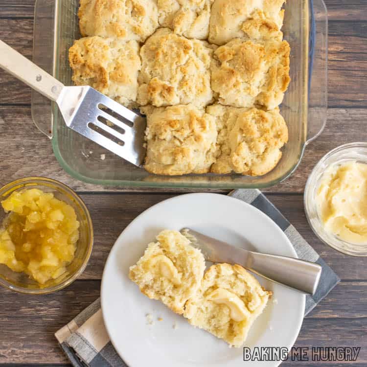 overhead shot of pan of biscuits and one sliced in half on plate