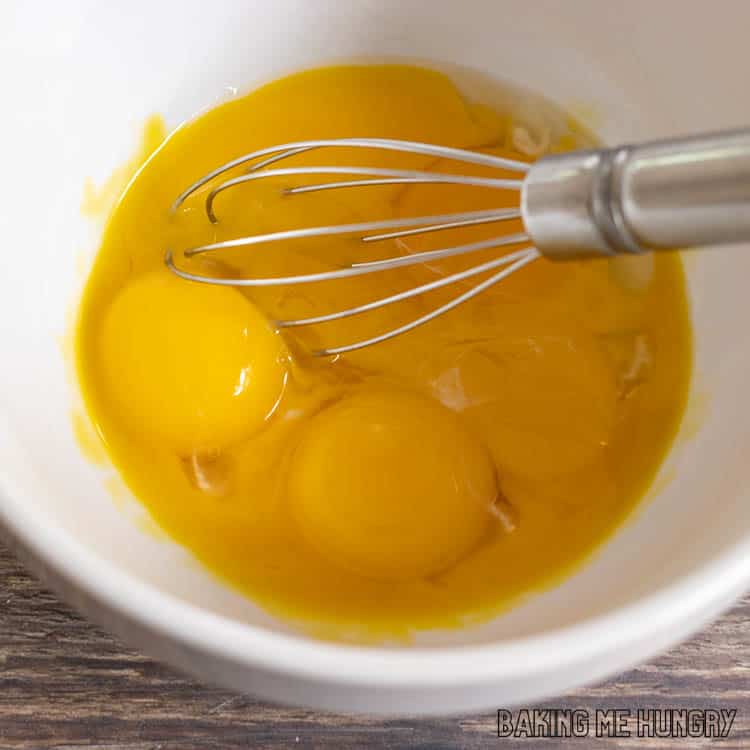 egg yolks in bowl with whisk