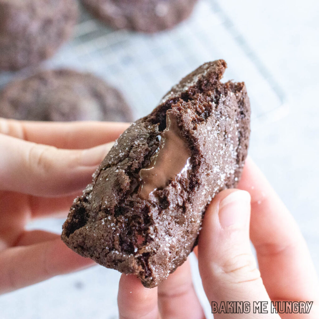 hands breaking open a molten lava cookie to show to melted chocolate center