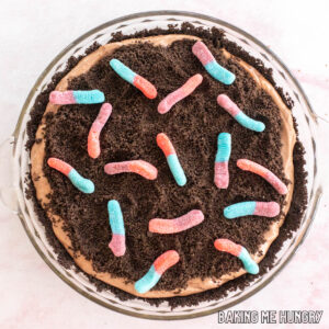 mud pie recipe with gummy worms shown from overhead in glass pie plate