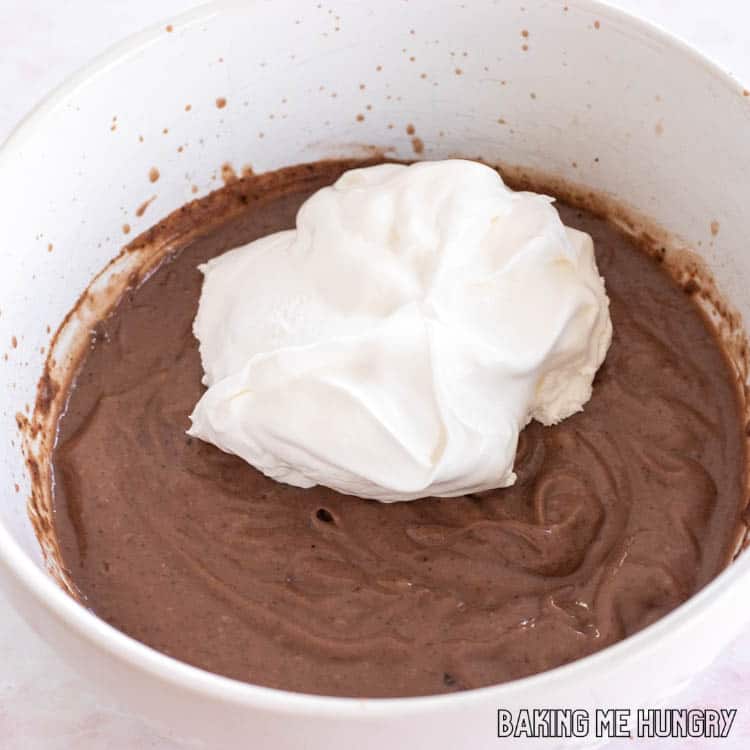 whipped topping on top of chocolate pudding on bowl