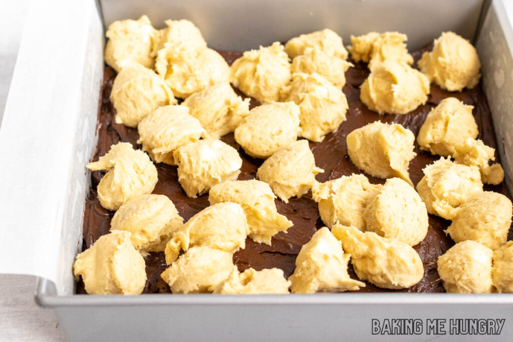scoops of cookie batter on top of brownie batter