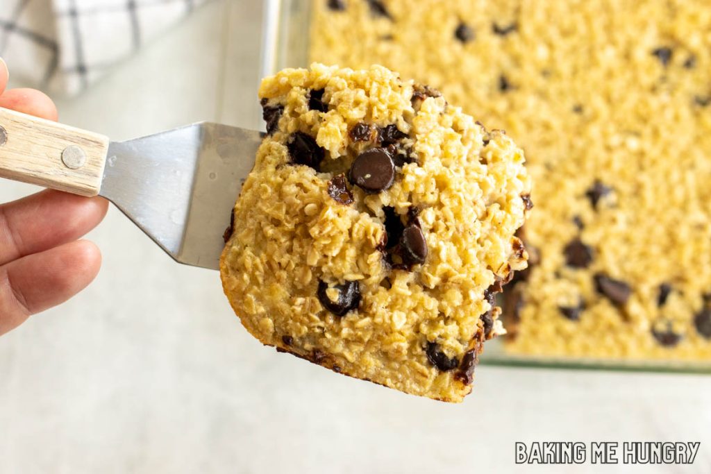 serving spatula lifting piece of baked chocolate chip oatmeal
