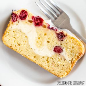 cranberry cream cheese bread sliced and on a plate showing the cream cheese swirl