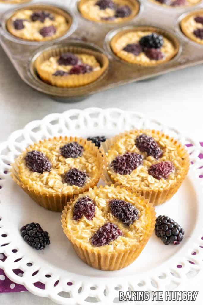 plate with banana blackberry oatmeal muffins with muffin tin behind