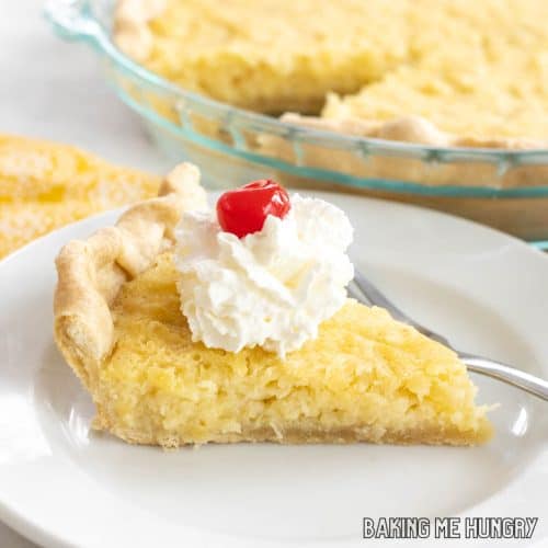 5 ingredient pineapple pie sliced and served on small plate with whipped cream and a cherry